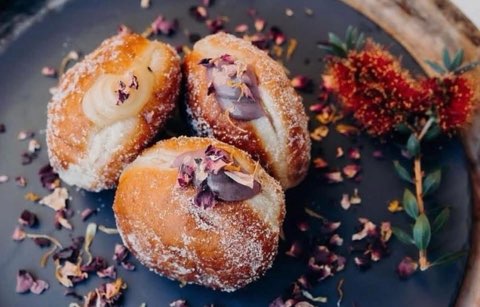 Fresh cream-filled doughnuts topped with rose petals
